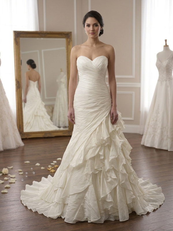 Front and back showcase of the private label Layla Demetrios size 10 wedding dress featuring an asymmetric ruched sweetheart bodice and a dramatic cascading ruffled skirt on a mannequin inside a luxury boutique.