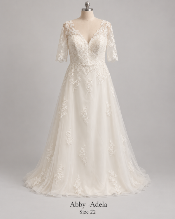 Front view of Adela Abby size 22 wedding dress with V-neck lace bodice, illusion sleeves and flowing A-line tulle skirt